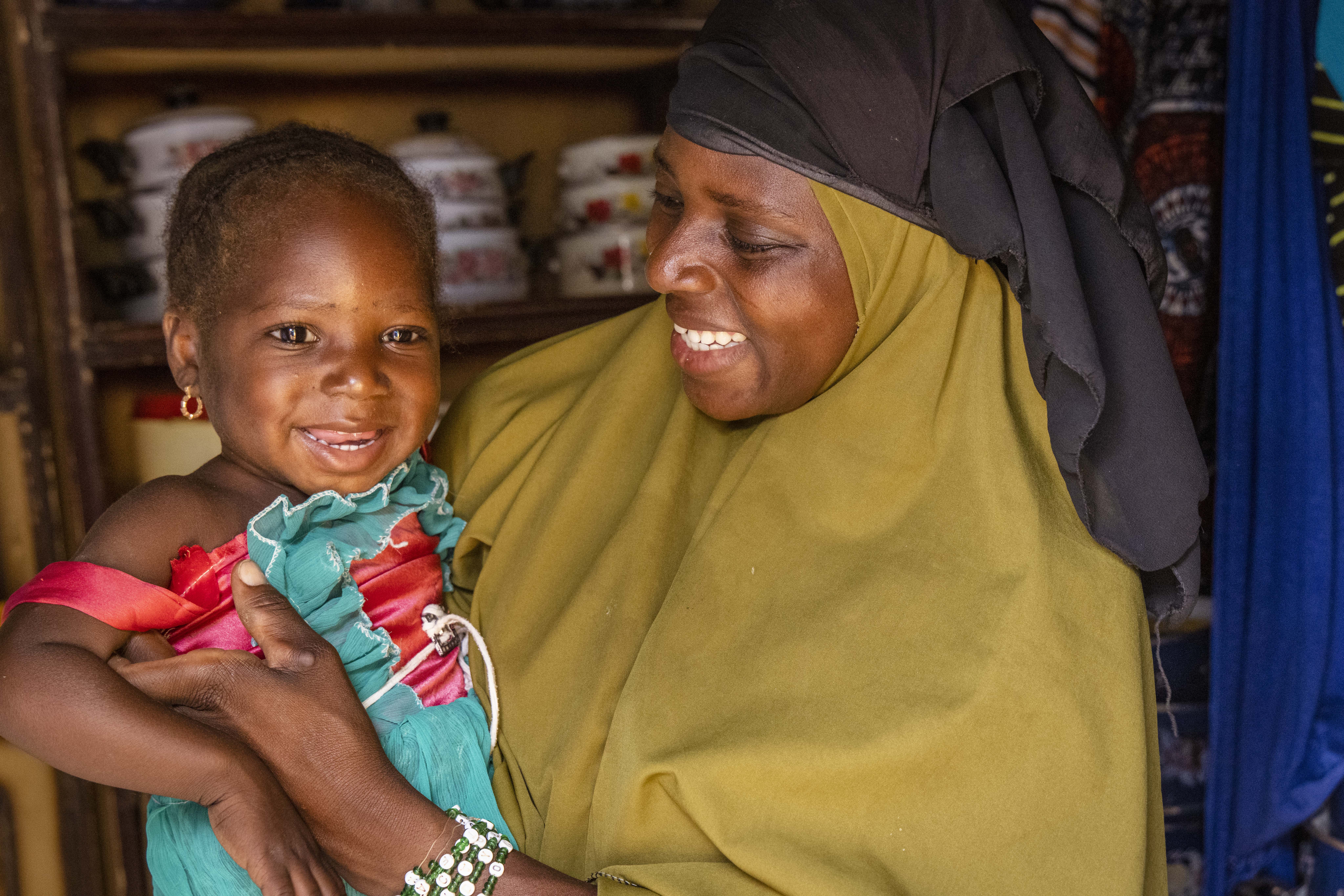 Woman holding child and smiling