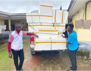 UNICEF staff unload large containers of polio vaccines from a truck, preparing for a vaccination campaign in Cameroon aimed at eradicating polio in the region.