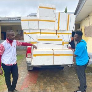 UNICEF staff unload large containers of polio vaccines from a truck, preparing for a vaccination campaign in Cameroon aimed at eradicating polio in the region.