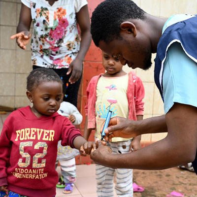 A health worker marking a child's finger with ink as part of the vaccination process.