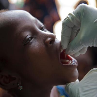 April 18, 2015, Madina Health Center, Guéckédou, Guinea. A girl swallows a vaccine against polio.