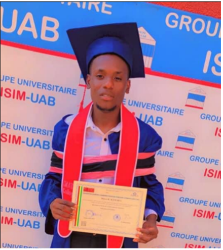 Moussa standing with his diploma