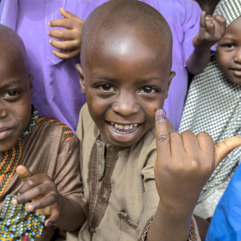 Children showing their pinky as a sign that they got the vaccine