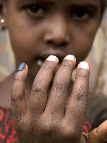 Little girl showing her marked pinky 