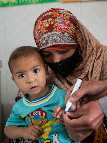 Little boy having his finger marked