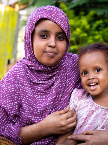Woman holding child and smiling