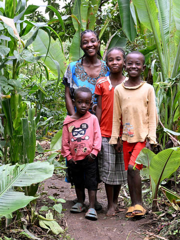 Woman and her three children smiling at the camera