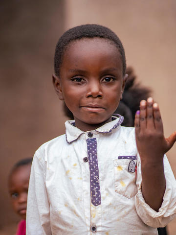 Little boy showing his marked hand meaning he took the vaccine drops